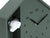 Horloge murale vert foncé avec tête de chien dans un compartiment latéral ; chiffres et aiguilles d'horloge bien visibles