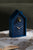 Horloge coucou bleu foncé sur fond avec oiseau et aiguilles dorés