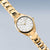 Montre femme dorée en diagonale : cadran blanc avec index, bracelet à maillons