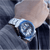 Herren-Armbanduhr am Handgelenk mit silbernem Band und blauem Zifferblatt