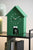 Horloge murale verte en forme de niche pour chien sur une étagère