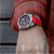 Herren-Chronograph-Armbanduhr am Handgelenk mit dunklem Zifferblatt und rotem Silikonband