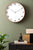 Horloge murale sur un mur avec un cadran blanc et un cadre aspect bois