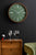 Grande horloge murale avec bordure en bois, cadran vert et aiguilles blanches