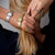 Silberne Damenuhr mit Milanaise-Armband, ovales Zifferblatt am Handgelenk im Detail