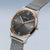 Herrenarmbanduhr am Handgelenk: graues Stoffband, dunkles Zifferblatt mit orangefarbenem Rand