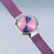Damenuhr am violetten Milanaise-Armband, silbernes Gehäuse mit mehrfarbigem Zifferblatt