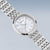 Montre pour femme avec boîtier rond et bracelet en métal argenté, cadran en nacre en détail