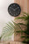 Horloge murale Karlsson au mur avec cadran noir, aiguilles et chiffres blancs