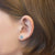 Boucles d'oreilles étoile Prinzessin Lillifee avec pierres bleu clair, roses et blanches sur l'oreille, couleur argent