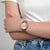 Montre pour femme au poignet avec bracelet en maille milanaise rose et cadran clair