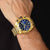 Montre chronographe pour homme au poignet avec cadran bleu et boîtier doré