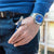 Montre chronographe pour homme portée au poignet avec cadran bleu et bracelet en acier inoxydable