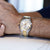 Montre bracelet pour homme au poignet avec bracelet bicolore en acier inoxydable et cadran blanc