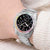 Montre pour femme au poignet avec cadran noir, lunette arc-en-ciel et bracelet en acier inoxydable