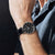 Montre homme Festina au poignet, cadran noir et bracelet en cuir noir