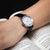 Montre pour femme au poignet avec bracelet en cuir noir et cadran blanc