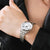 Montre pour femme au poignet, bracelet en métal argenté et cadran blanc avec chiffres noirs