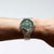 Bracelet de montre pour homme avec cadran vert au poignet, bracelet en acier inoxydable