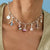 Collier argenté avec pendentifs colorés et motif Snoopy sur socle rose