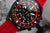 Vostok Europe Chronograph-Zifferblatt mit schwarzer Anzeige, rotem Außenring und bunten Markierungen.