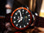 Vostok Europe Herrenuhr mit schwarzem Gehäuse, orange Lünette und dunklem Lederband