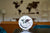 Horloge de table avec cadran blanc et carte du monde, sur un pied argenté