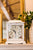 Horloge de table blanche avec cadran orné de motifs floraux et poignée de couvercle dorée