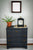 Horloge de table Hermle sur commode sombre avec cadran blanc et chiffres romains
