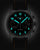 Montre homme avec boîtier sombre, chiffres lumineux bleus et bracelet en cuir noir avec surpiqûre