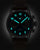 Montre homme avec boîtier et bracelet noirs, cadran sombre avec chiffres lumineux