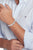 Au poignet : bracelet à maillons en acier inoxydable avec logo Tommy Hilfiger en relief, maillons argentés