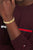 Gliederarmband mit goldfarbenen, strukturierten Gliedern und kleinem Logo am Handgelenk