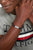 Bracelet en cuir tressé au poignet, noir avec fermoir argenté.