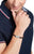 Geflochtenes Lederarmband, dunkelbraunes Zopfmuster, silbernes Mittelstück am Handgelenk