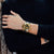 G‑SHOCK Herrenarmbanduhr am Handgelenk: goldfarbenes Gehäuse, schwarzes Band