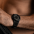 Montre bracelet pour homme au poignet, vue latérale avec boîtier noir et bracelet en caoutchouc