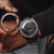 Holzuhr-Chronograph mit schwarzem Zifferblatt, sichtbar im Detail am Handgelenk