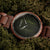 Holzkern-Armbanduhr mit braunem Holzarmband und rundem Gehäuse, dunkelgrünes Blattzifferblatt