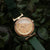 Damen-Armbanduhr: rundes Holz-Zifferblatt mit goldfarbenem Gehäuse und grünem Lederband