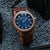 Holzkern Herrenuhr am Handgelenk: blaues Zifferblatt, braunes Holzgehäuse und Holzband
