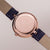 Holzkern Damenuhr: roségoldfarbenes Gehäuse von der Rückseite mit Gravur, violettes Lederarmband