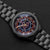 Herrenarmbanduhr mit schwarzem Metallband, blau-grauem Ziffernblatt mit roten Akzenten