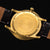 Rückseite der Herrenuhr: gravierter goldfarbener Boden, braunes Lederband, Edelstahlgehäuse