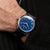 Herrenarmbanduhr am Handgelenk mit blauem Zifferblatt und dunkelblauem Lederarmband
