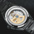 Herrenuhr mit Saphirglasboden: sichtbares Automatikwerk mit goldenen Zahnrädern