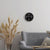 Horloge murale sur un mur avec un cadran noir et un cadre en métal