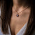Collier sur le décolleté avec pendentif rond en nacre bleue, chaîne délicate