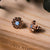 Holzkern-Ohrring mit blauem Perlmutt, runde Zierfassung im Detail