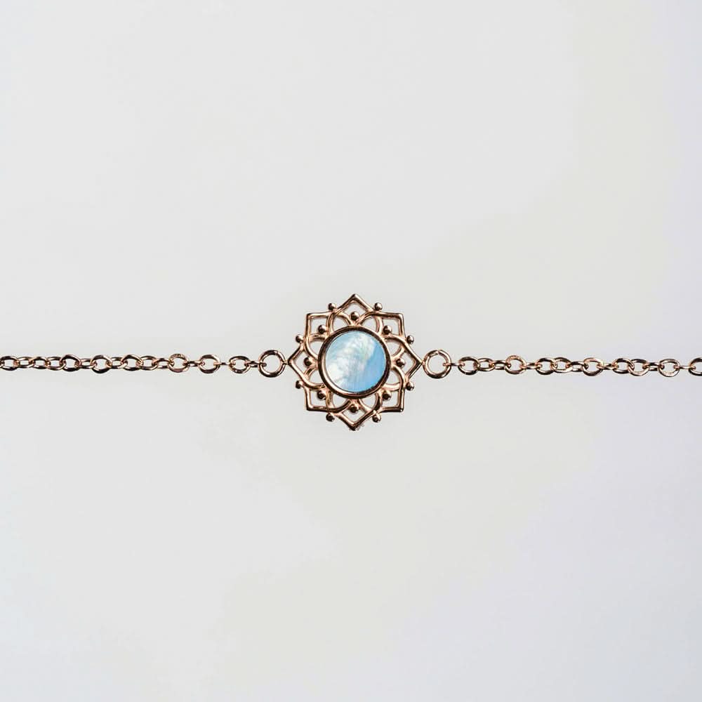 Bracelet couleur cuivre avec pendentif rond en nacre bleue dans un cadre filigrane